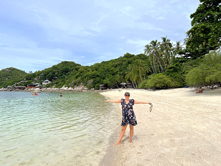 Top Rated Beaches in Koh Tao Thailand - Shark Bay Haad Tien Beach Koh Tao, lady standing in the sand with arms up