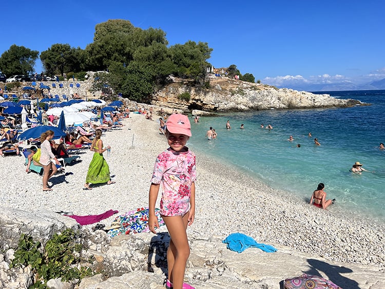 Bataria Beach in Corfu in September, Greece, young girl standing on the stone Bataria Beach