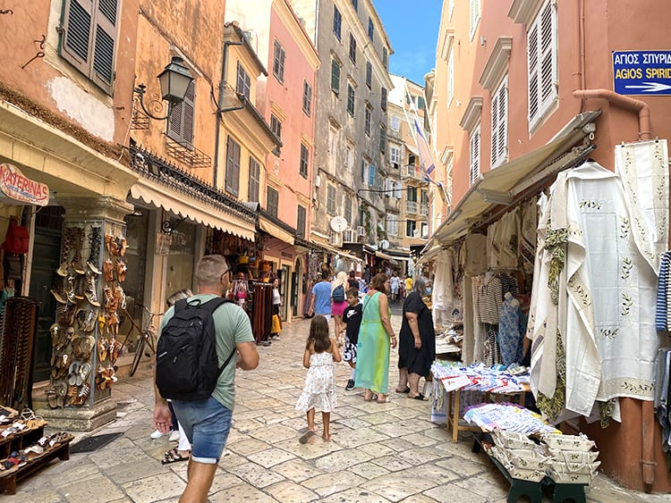 Exploring Corfu Old Town, Greece, Father and Daughter walking up the cobble stone path, shops
