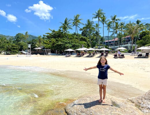 Koh Tao vs Koh Samui, young girl standing on the rock at the beach resort in Koh Samui, Thailand