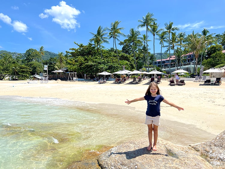 Koh Tao vs Koh Samui, young girl standing on the rock at the beach resort in Koh Samui, Thailand