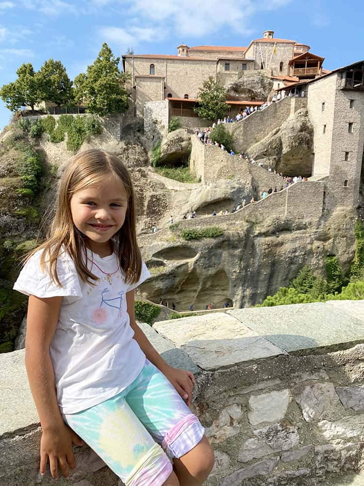 The Great Meteoron Monastery in Meteora Greece, young girl with the monastery in the background
