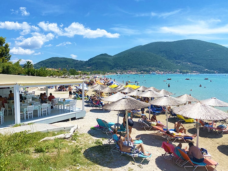 Vasiliki in Lefkada, Greece, view of the beach, restaurant, sunbeds, parasols and tourists