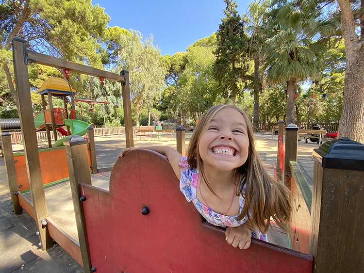 Family Holiday in Crete, Greece, Rehymnon play park, playground, young girl smiling at the playpark