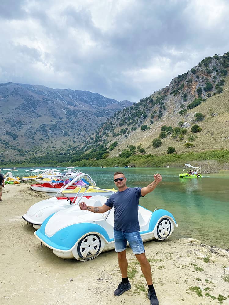 Family vacation in Crete, Lake Kournas Crete, Greece, man standing next to the lake, pedal boats