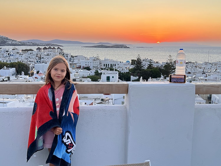 Mykonos in September, Greece - Where to stay in Mykonos, young girl on the balcony, sunset over the Old Town