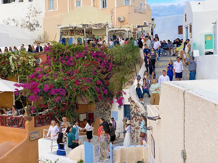 Santorini in September, Greece - Oia sunset spot, people crowding on the footpaths on the town
