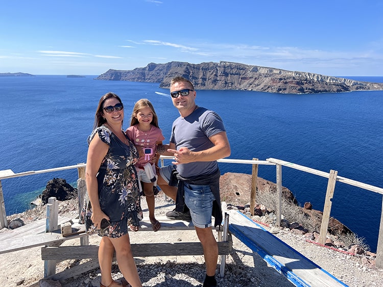 Santorini in September, Greece - family posing at the lookout island in the distance