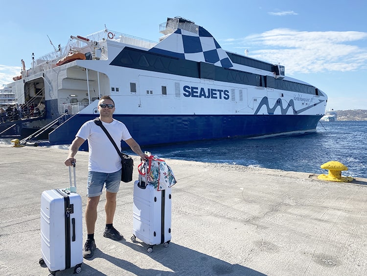 Santorini in September, Greece - man with luggage in front of the Ferry in Fira