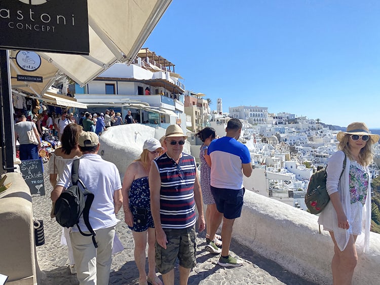 Santorini in September, Greece - people walking in the footpath in Fira town