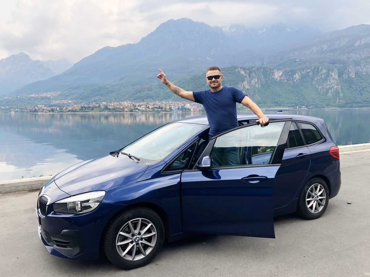 Man standing in car whilst having some leisure time on business travel