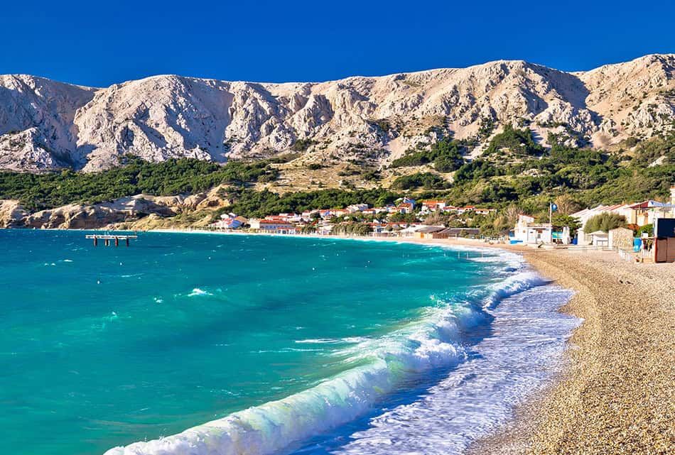 Baska. Idyllic pebble beach with high waves in town of Baska, Is